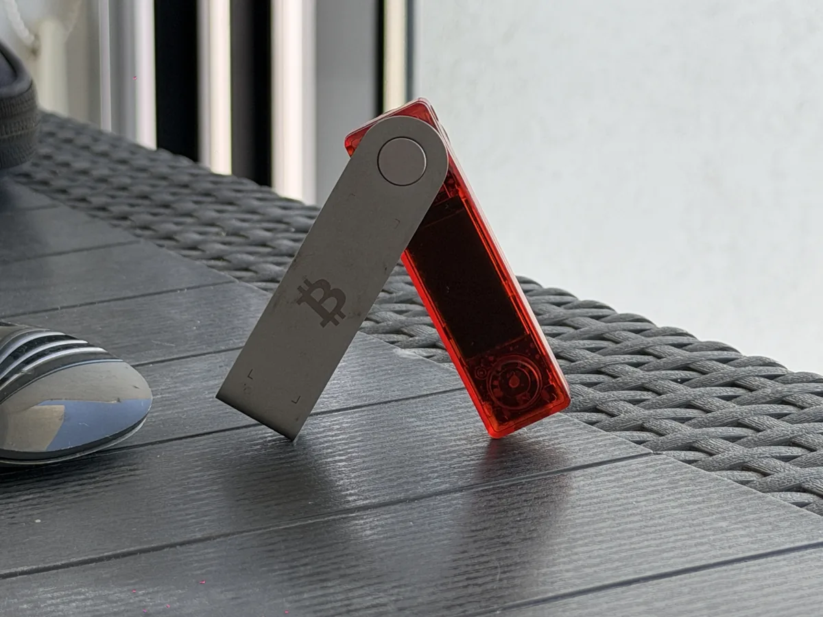 Mein neuer Ledger Nano X in der transparenten BTC-Orange-Edition, aufgeklappt auf einem Gartentisch