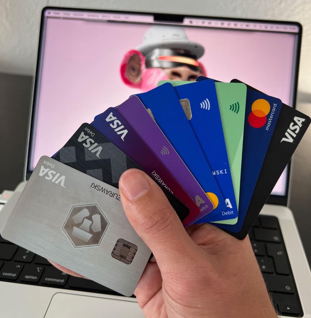 Meine Krypto-Karten 2022 aufgefächert in der Hand: Crypto.com Icy White (Metall), Bitpanda, Nexo, Binance und weitere